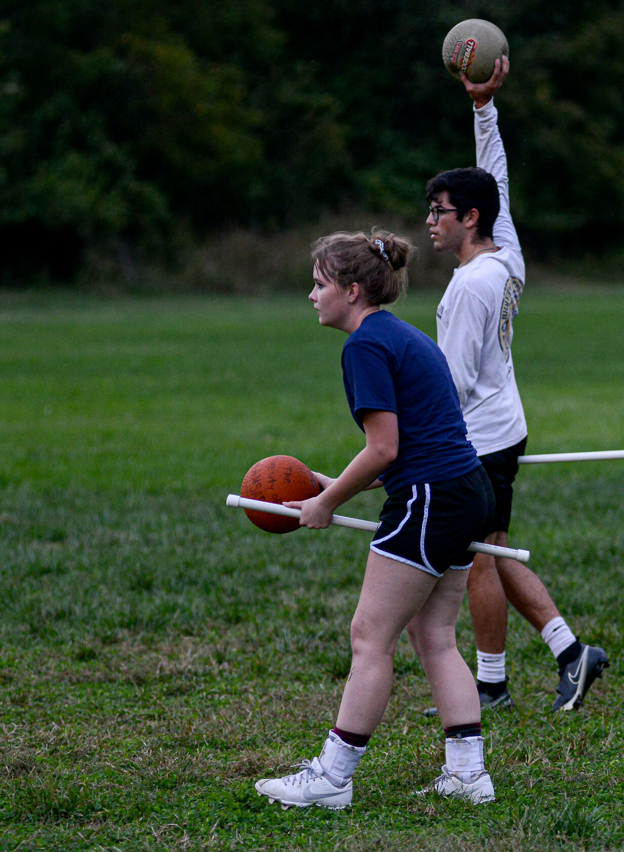 Keighlyn Johnson, front, eyes her opponents as Vincent Reyes gets ready to throw the ball during quidditch practice